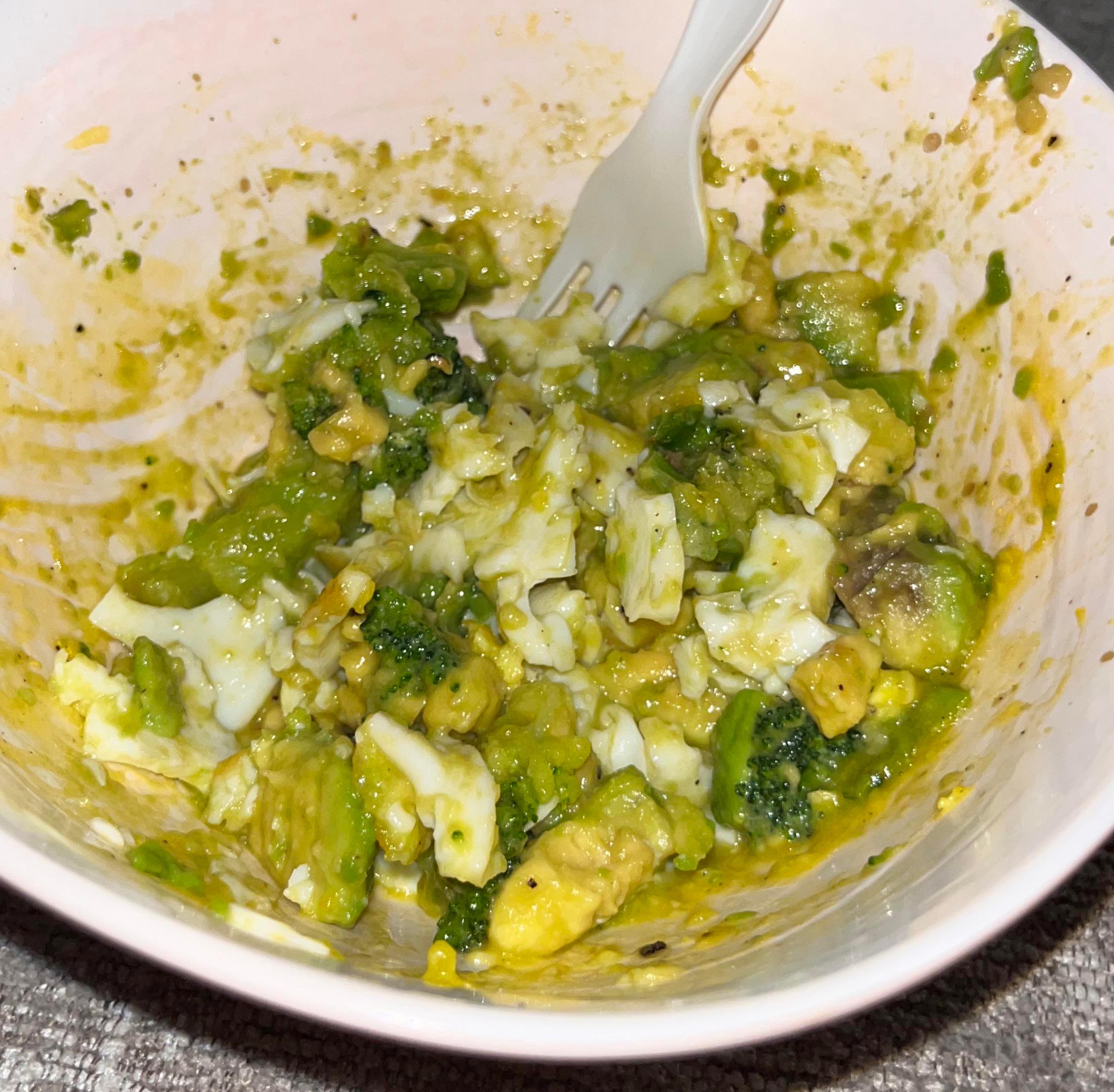 close up of avocado and eggs being mashed together in a bowl