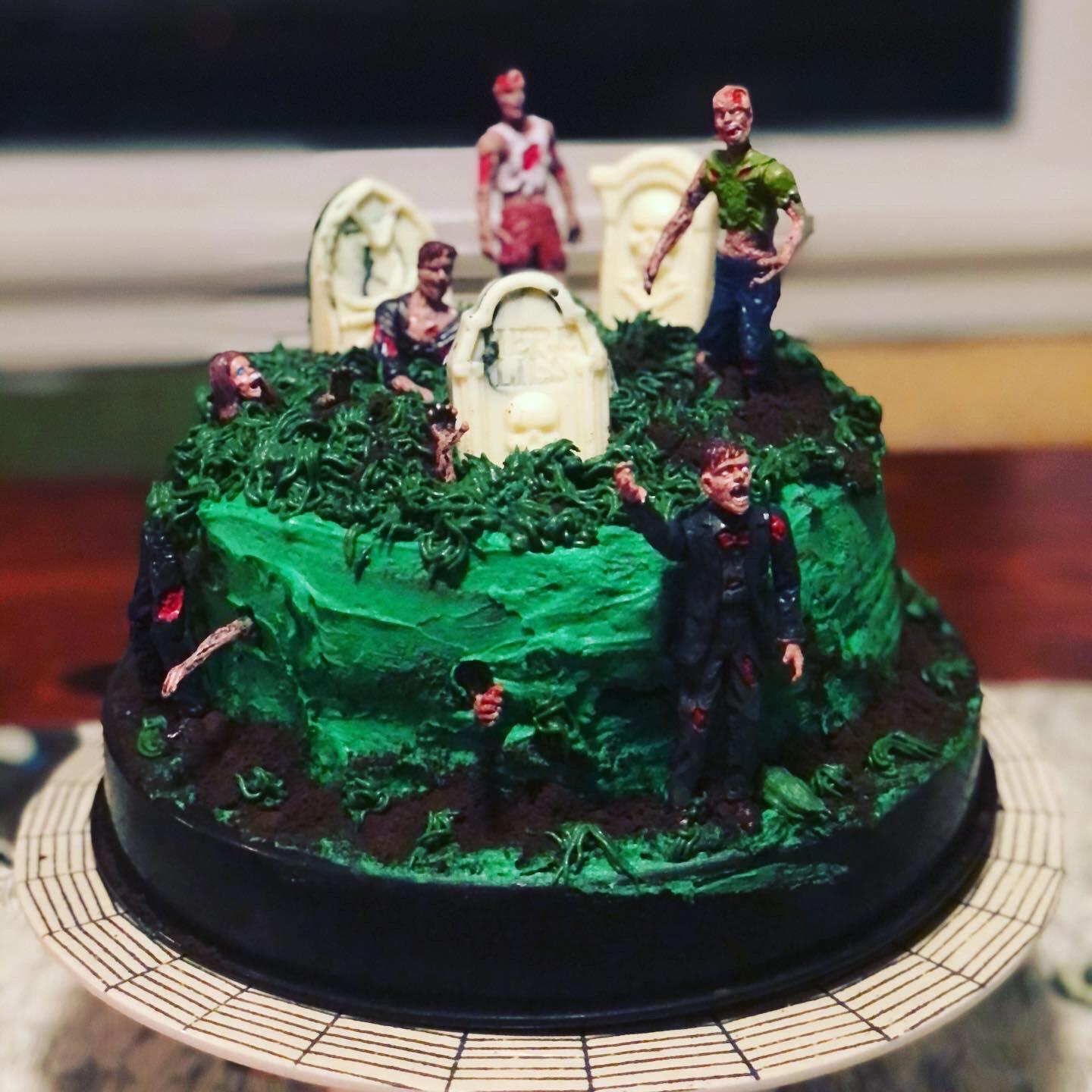 a decadent chocolate zombie cake with green frosting and edible zombie decorations
