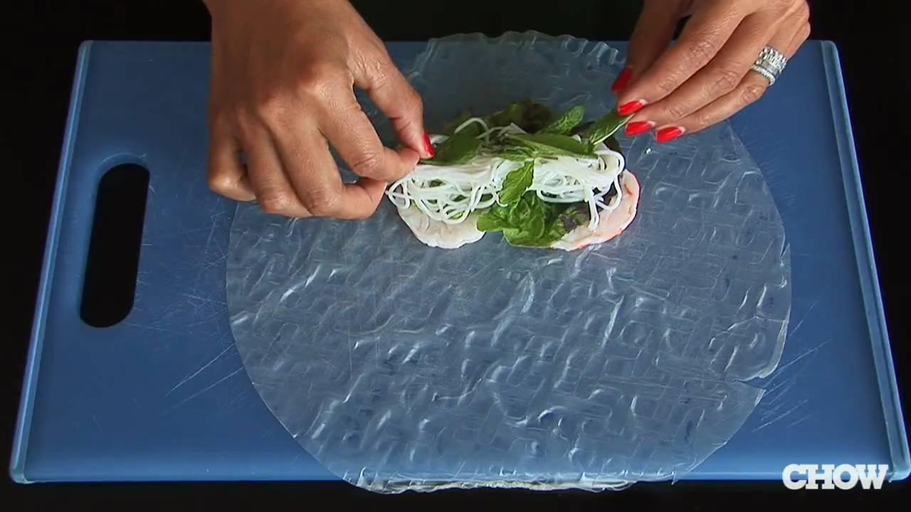 person assembling spring rolls on a clean counter