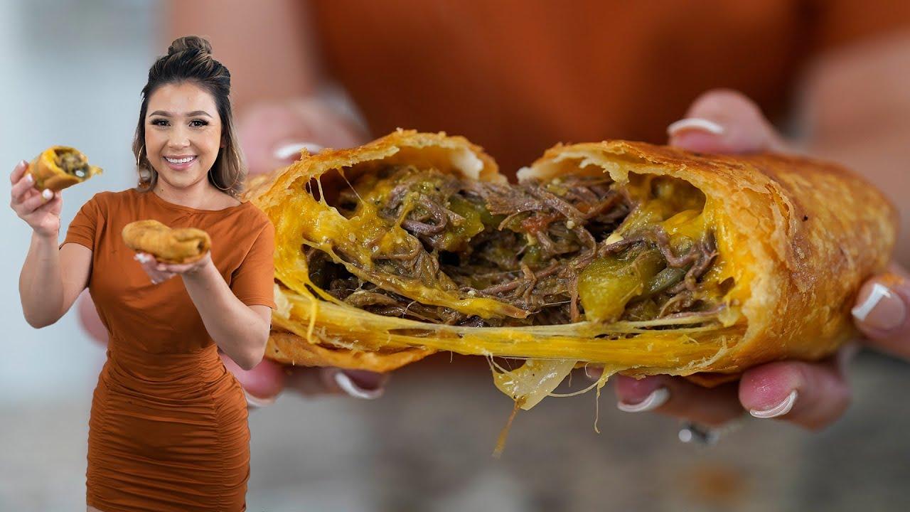 Someone taking a bite out of a Chimichanga while holding a mug of chai latte, showcasing the steam and filling