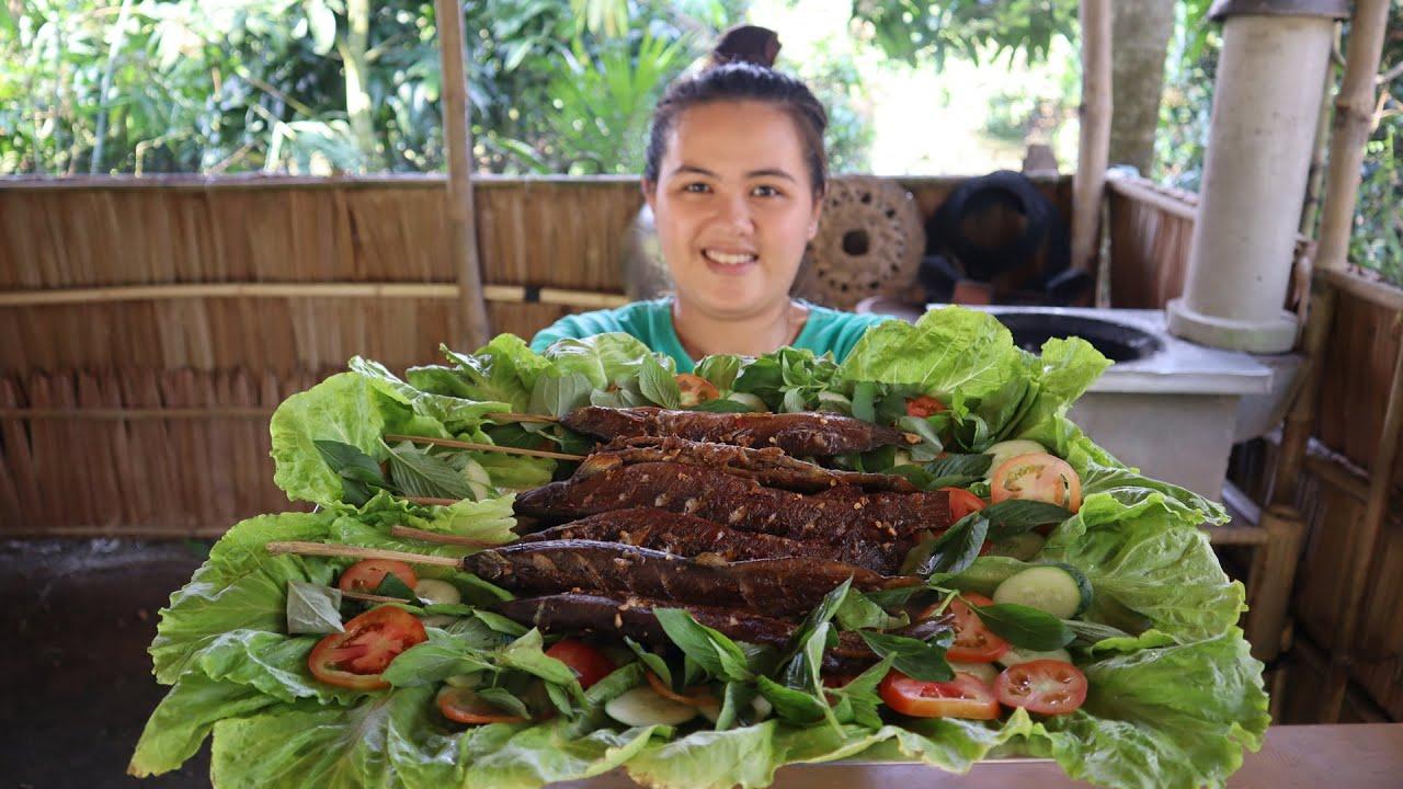 a person grilling loach on a barbecue