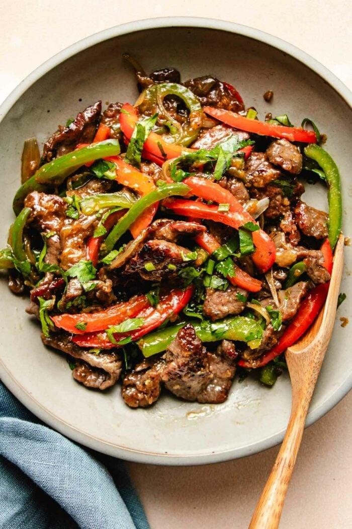close up shot of sweet and spicy beef stir-fry with bell peppers and onions