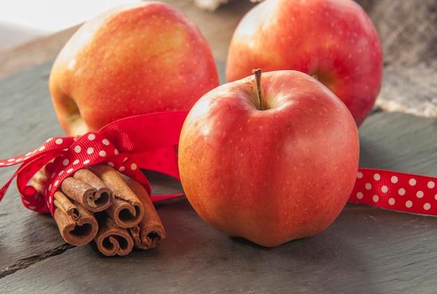 close up of baked apples with cinnamon on a rustic wooden table