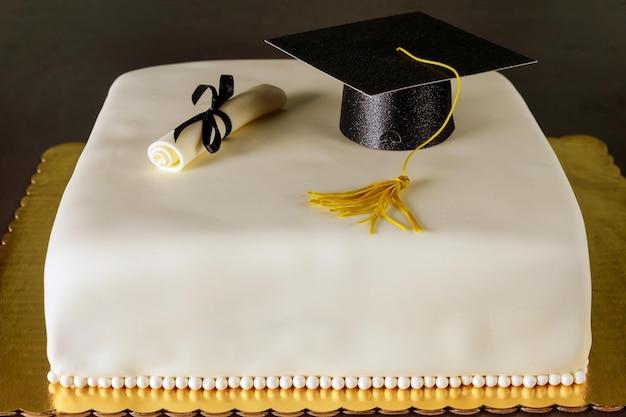 overhead shot of a beautifully decorated graduation cookie cake on a wooden table, with graduation caps and diplomas scattered around