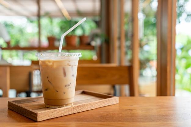 An inviting glass of Iced Caffè Latte on a wooden table