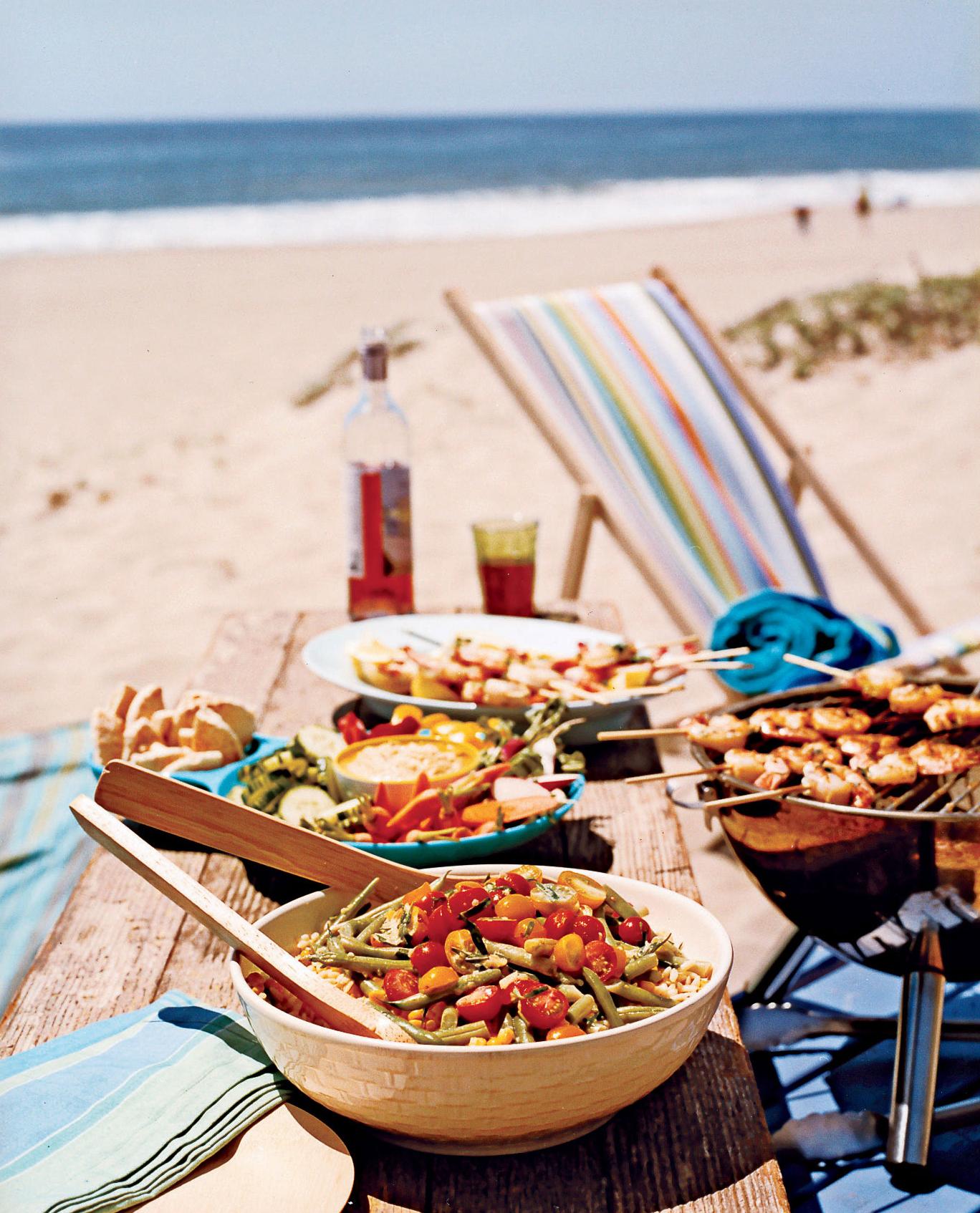 overhead shot of a colorful pasta salad being served outdoors at sunset