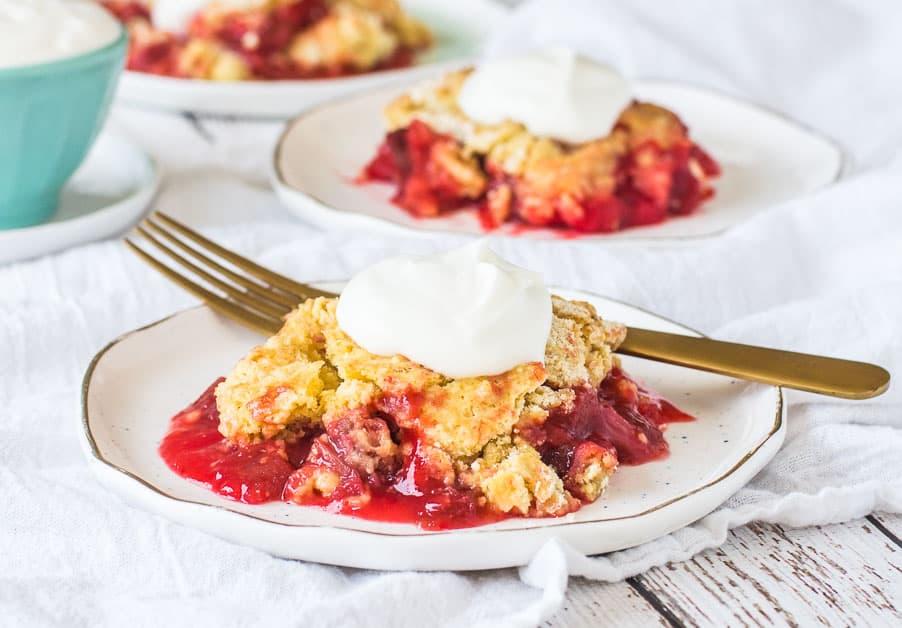 Close-up of rhubarb dump cake being served with a spoon, showing the moist texture