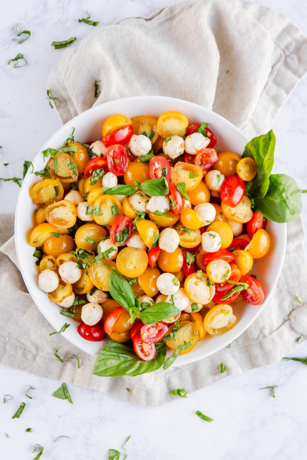 A person holding a bowl of Caprese Sorbet, with a sun-drenched tomato garden in the background