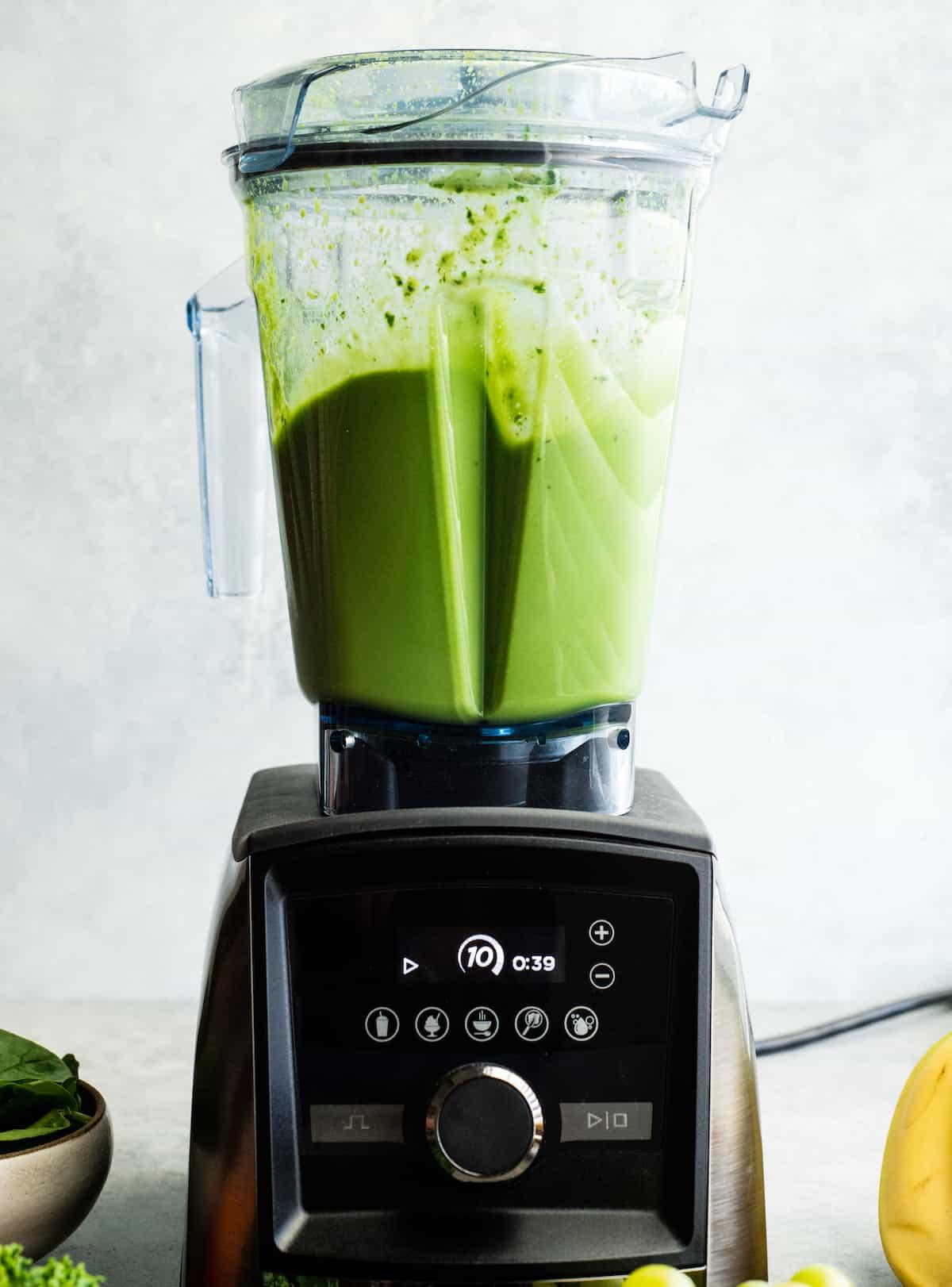 a close-up of a blender in action, blending the ingredients of a green smoothie