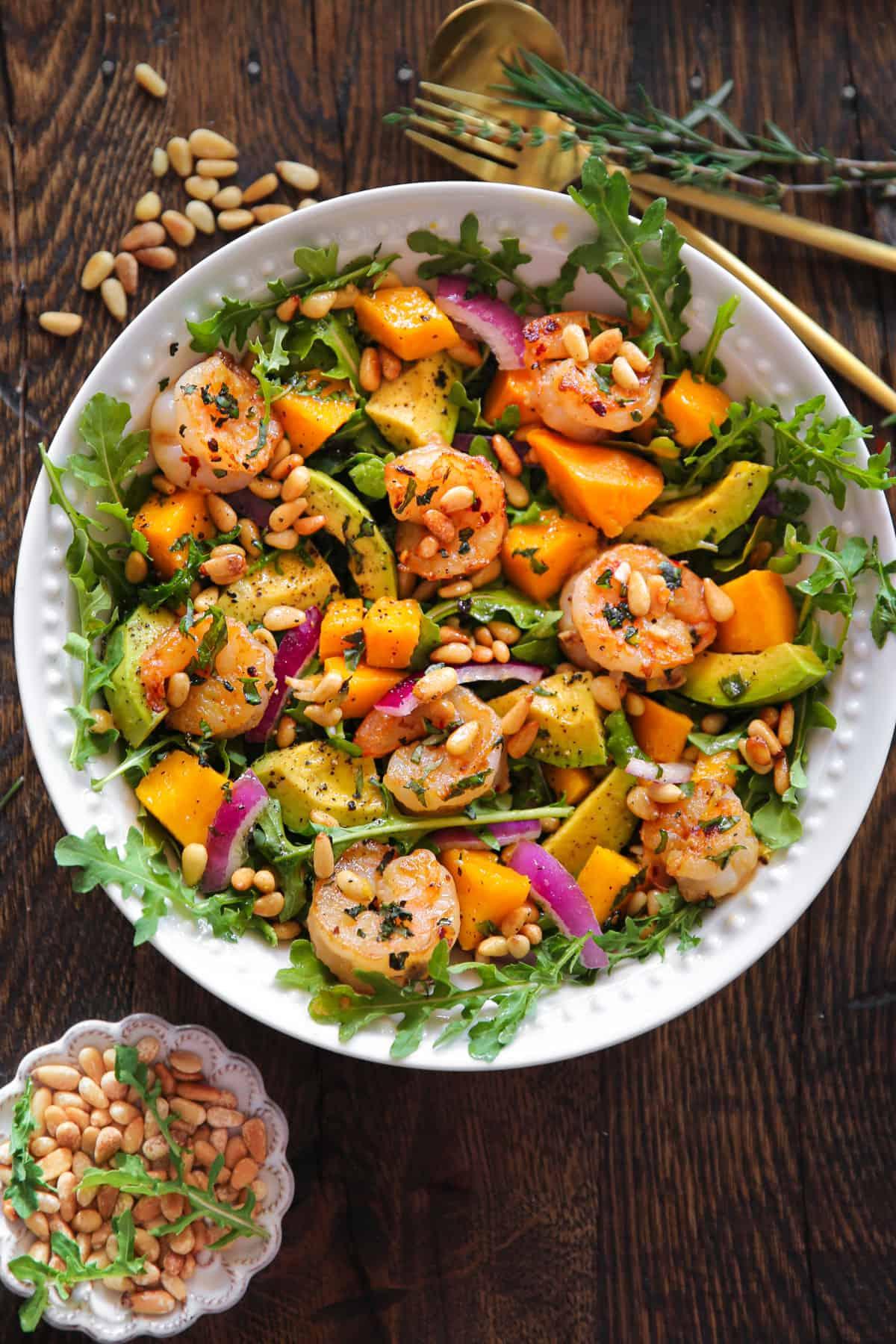 ingredients for shrimp avocado salad laid out on a wooden table