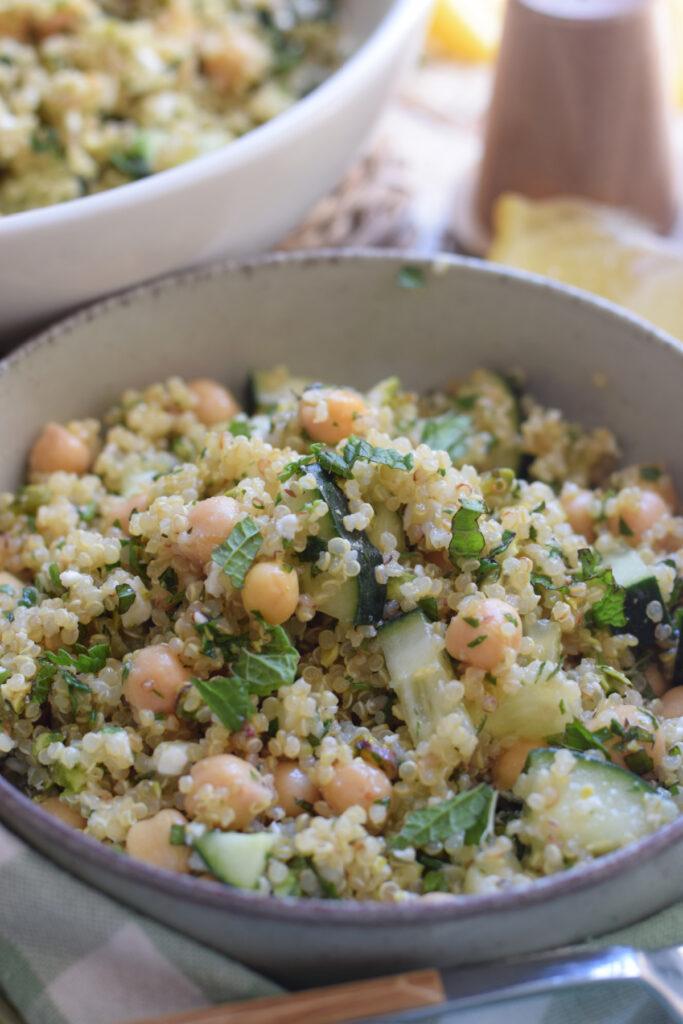 close-up of quinoa salad being tossed with lemon vinaigrette