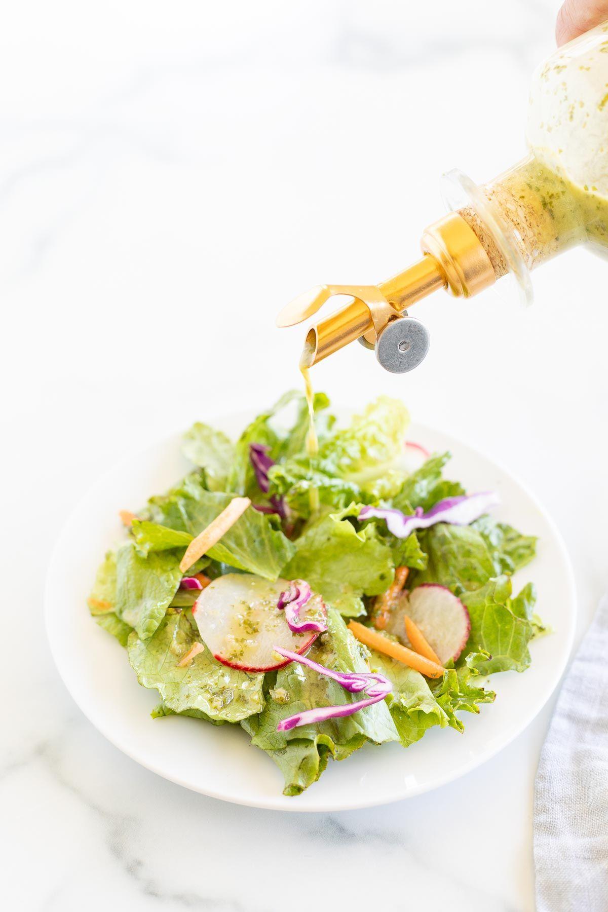 cilantro lime dressing being poured over a salad
