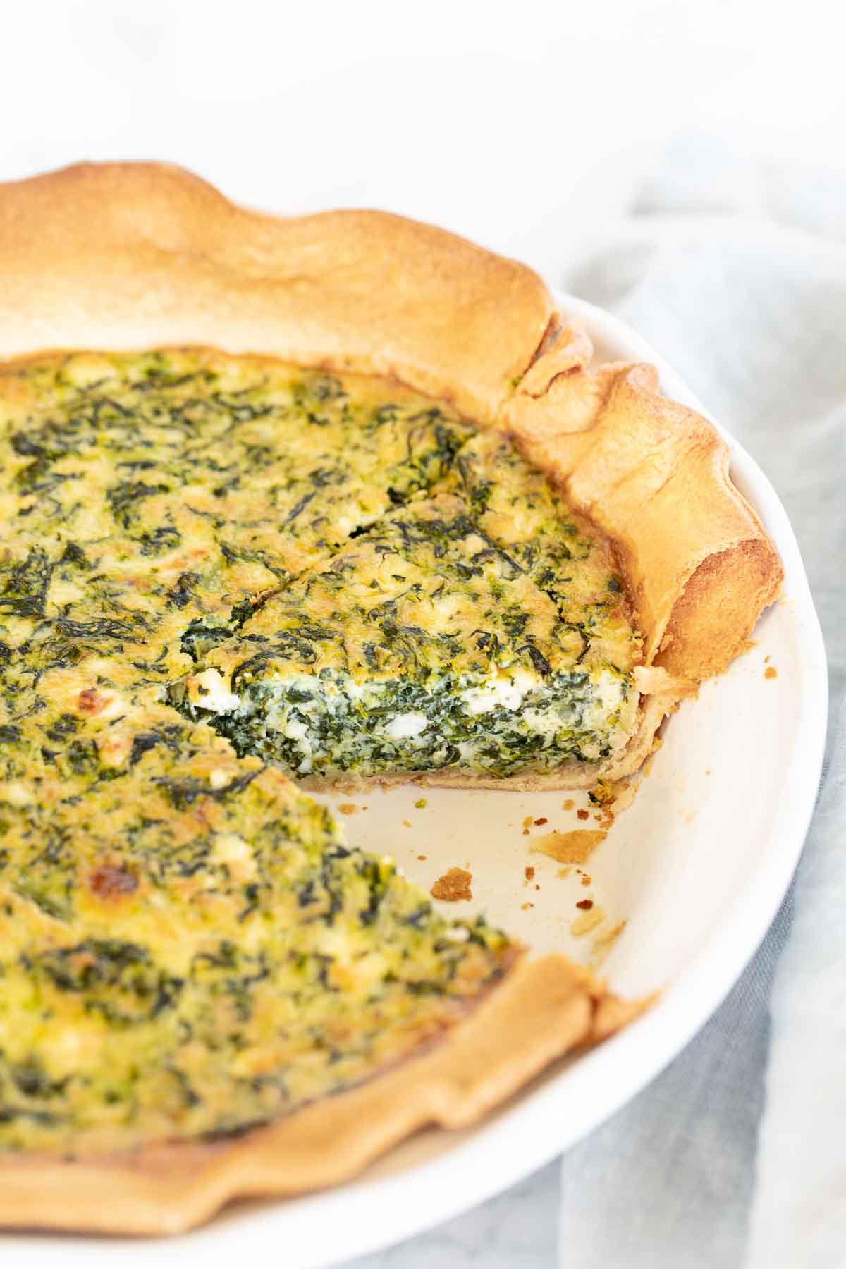 close-up of the texture and ingredients inside the quiche, showing the spinach, feta, and egg custard