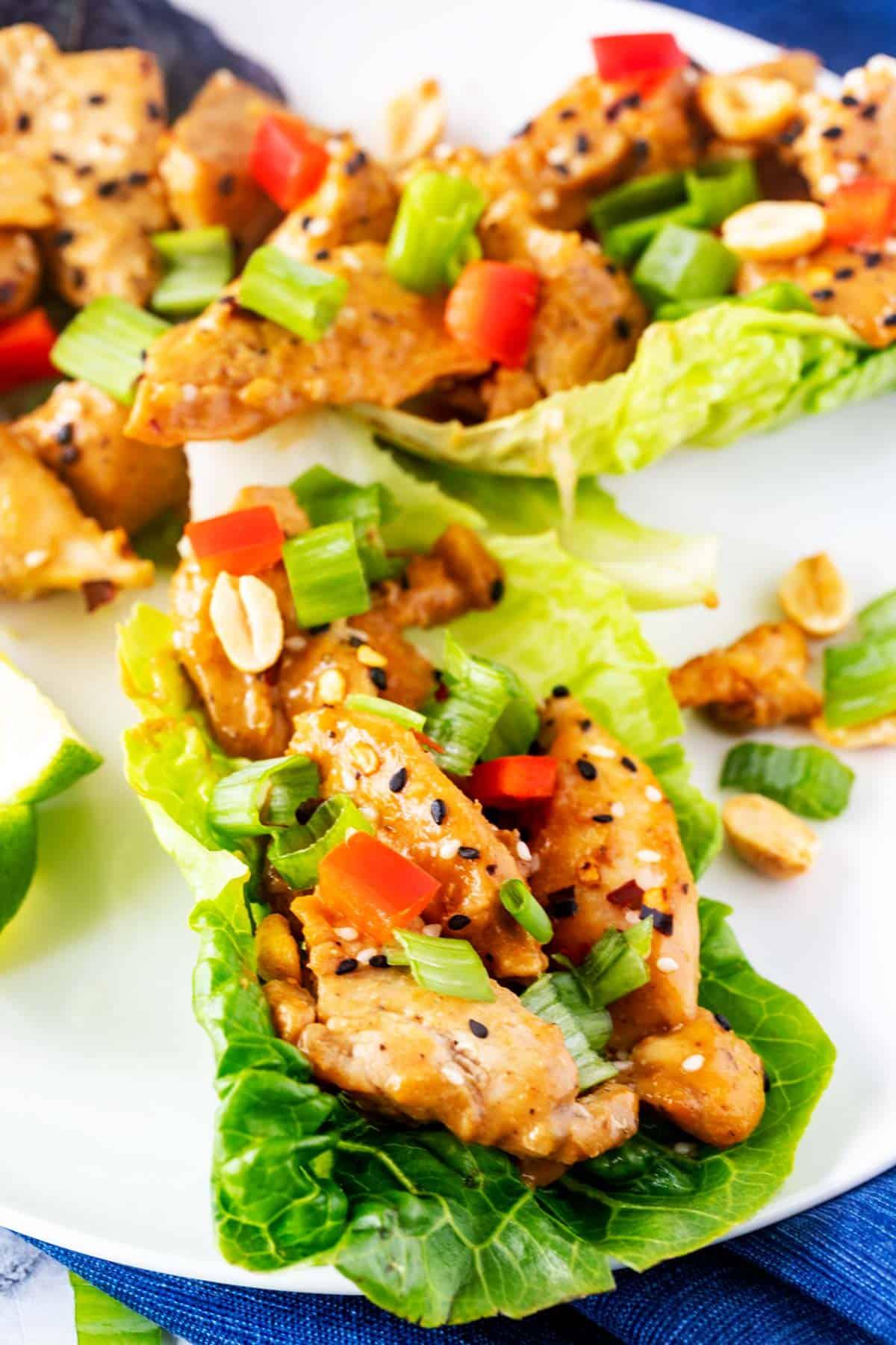 Close-up of beautifully arranged keto chicken lettuce wraps on a wooden platter