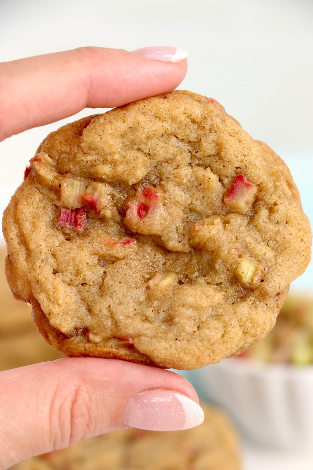 a person taking a bite of a rhubarb protein cookie