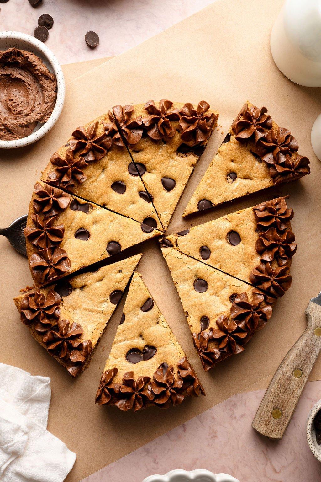 close-up shot of a slice of the cookie cake being cut, revealing the soft, chewy interior and layers of frosting