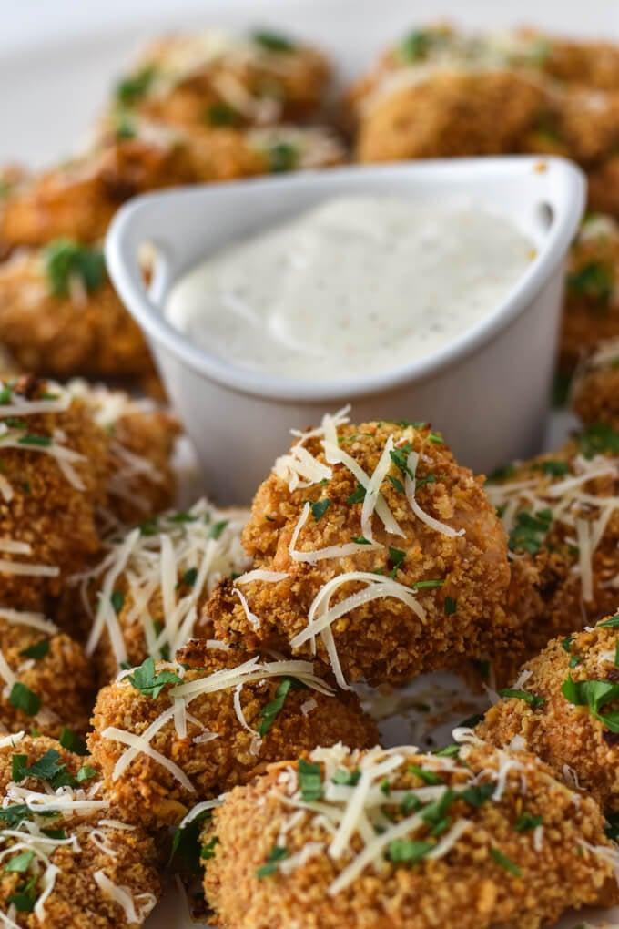assortment of chicken parmesan cookies displayed on a platter, some with parsley garnish