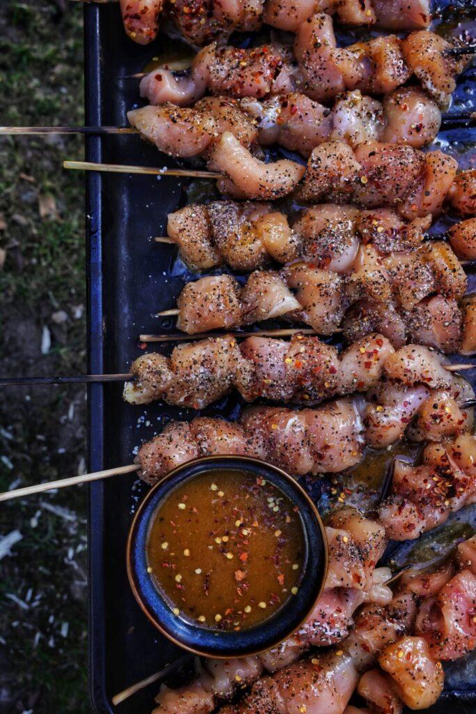 chicken satay skewers being grilled on a barbecue