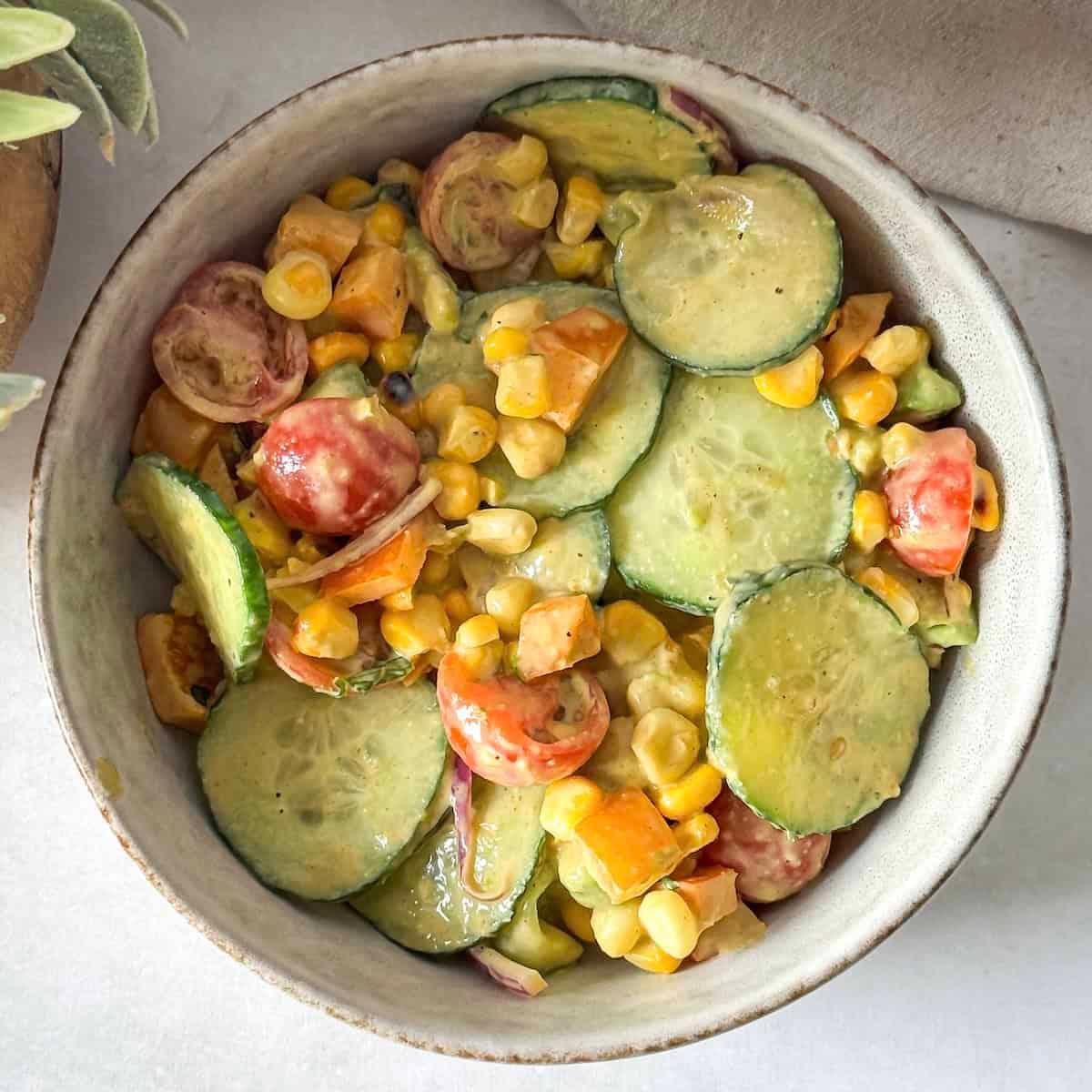 Overhead shot of Elote Cucumber Salad in a serving bowl