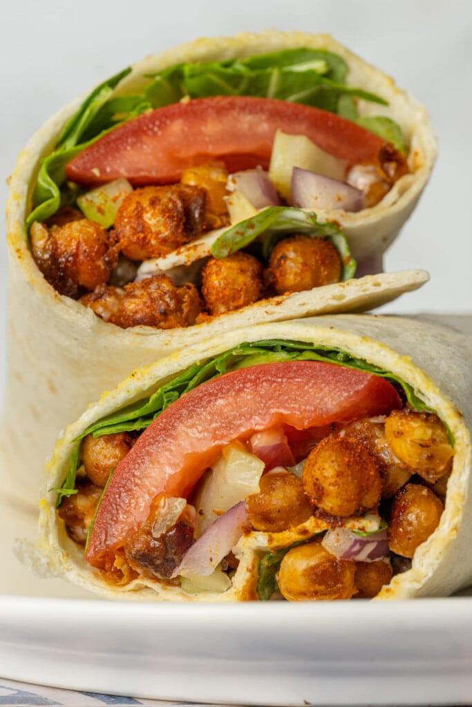 close-up of someone assembling a buffalo chickpea wrap