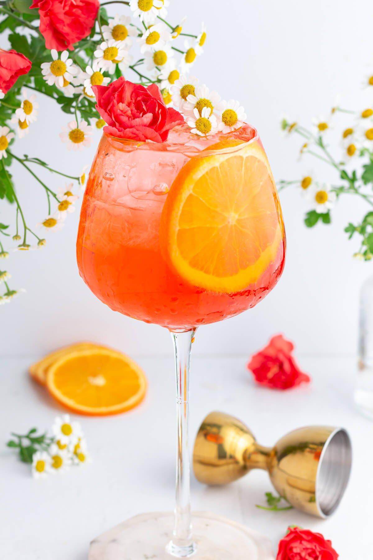Close-up of a vibrant orange Hugo Spritz with bubbles