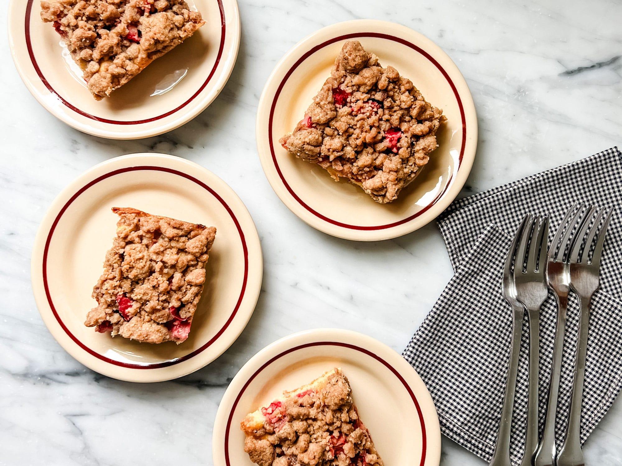 a plate of rhubarb crumb bars with a scoop of vanilla ice cream on top
