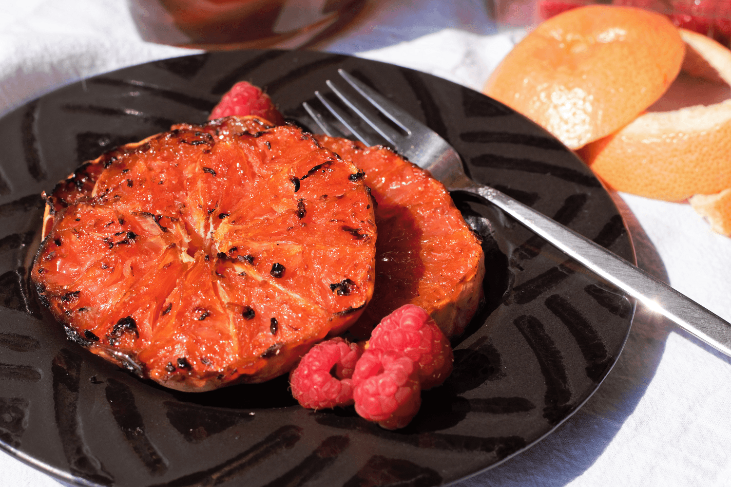 person adding honey to a grilled grapefruit half