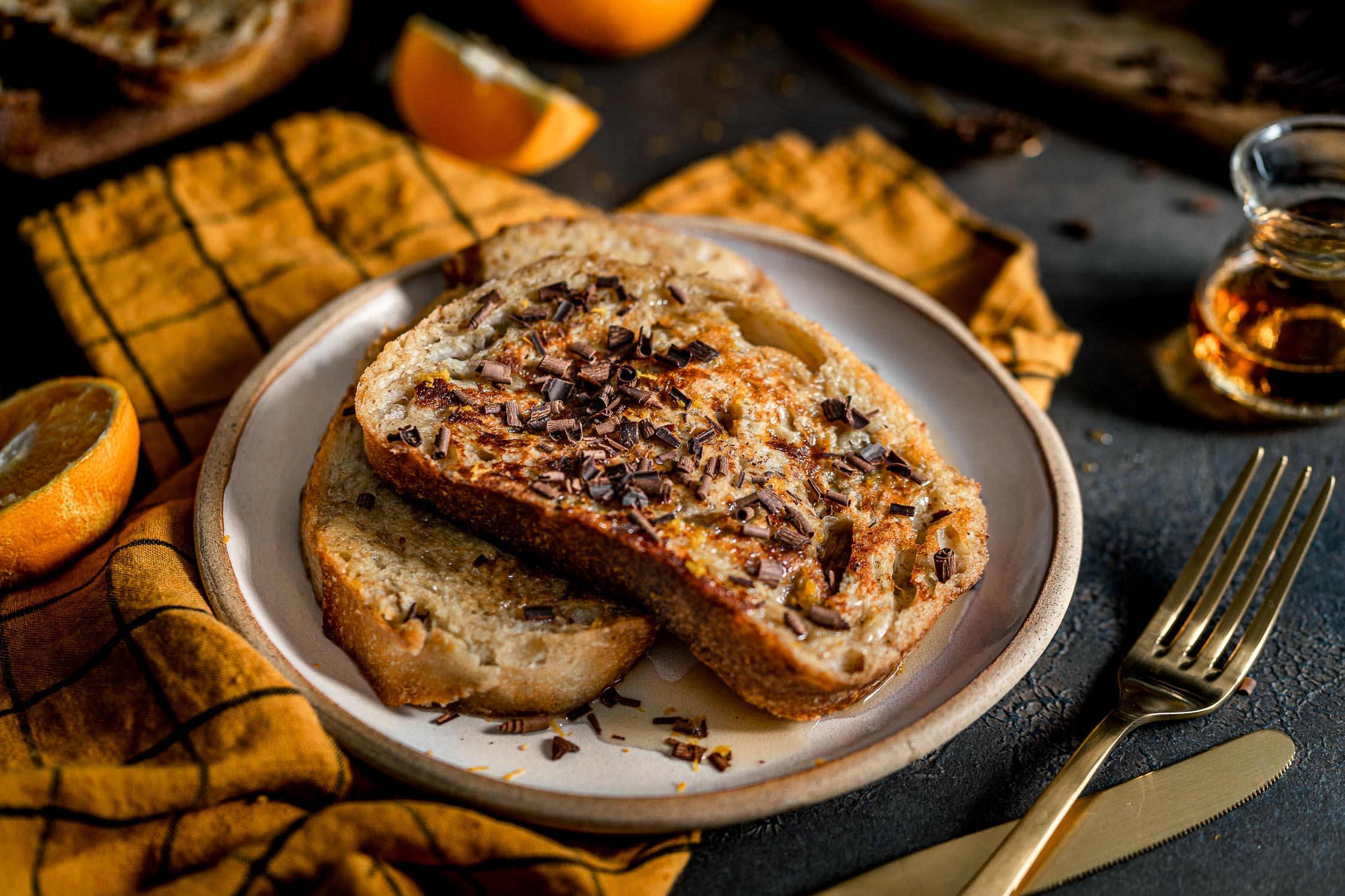 A person serving a slice of Grand Marnier Rhubarb French Toast Bread on a plate