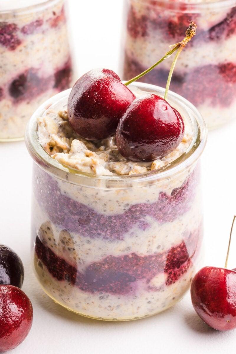 close up shot of cherry chocolate overnight oats in a clear glass jar