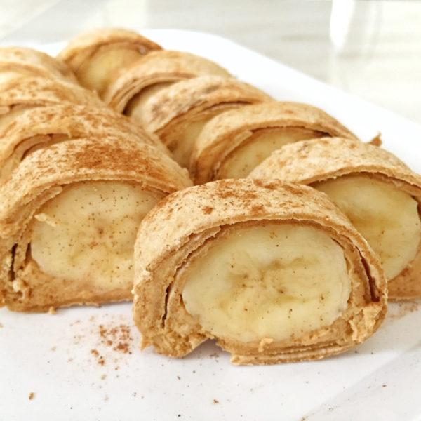 close-up of peanut butter and banana sushi rolls on a plate