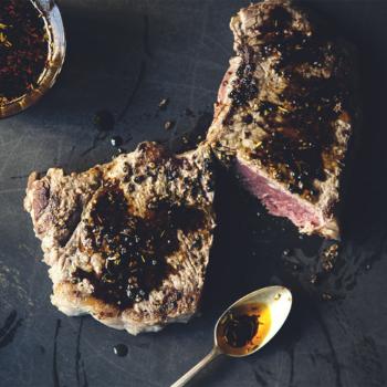 Close-up shot of black garlic rhubarb relish being spooned onto a grilled steak