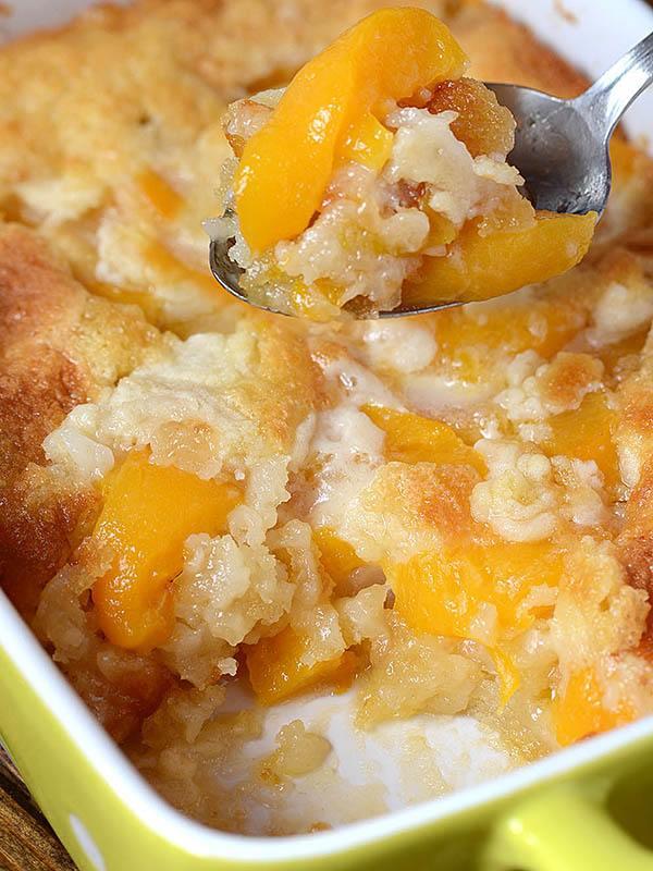 a close up shot of a milk chocolate peach cobbler with peaches overflowing