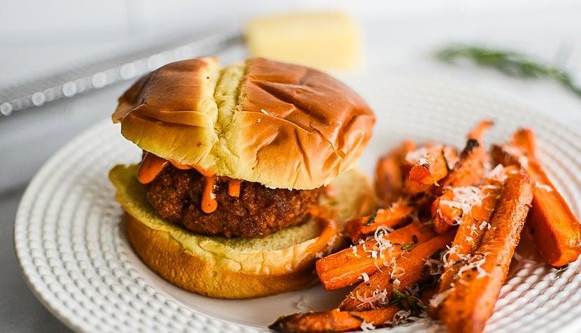 A bowl of honey garlic parmesan carrot fries next to a burger