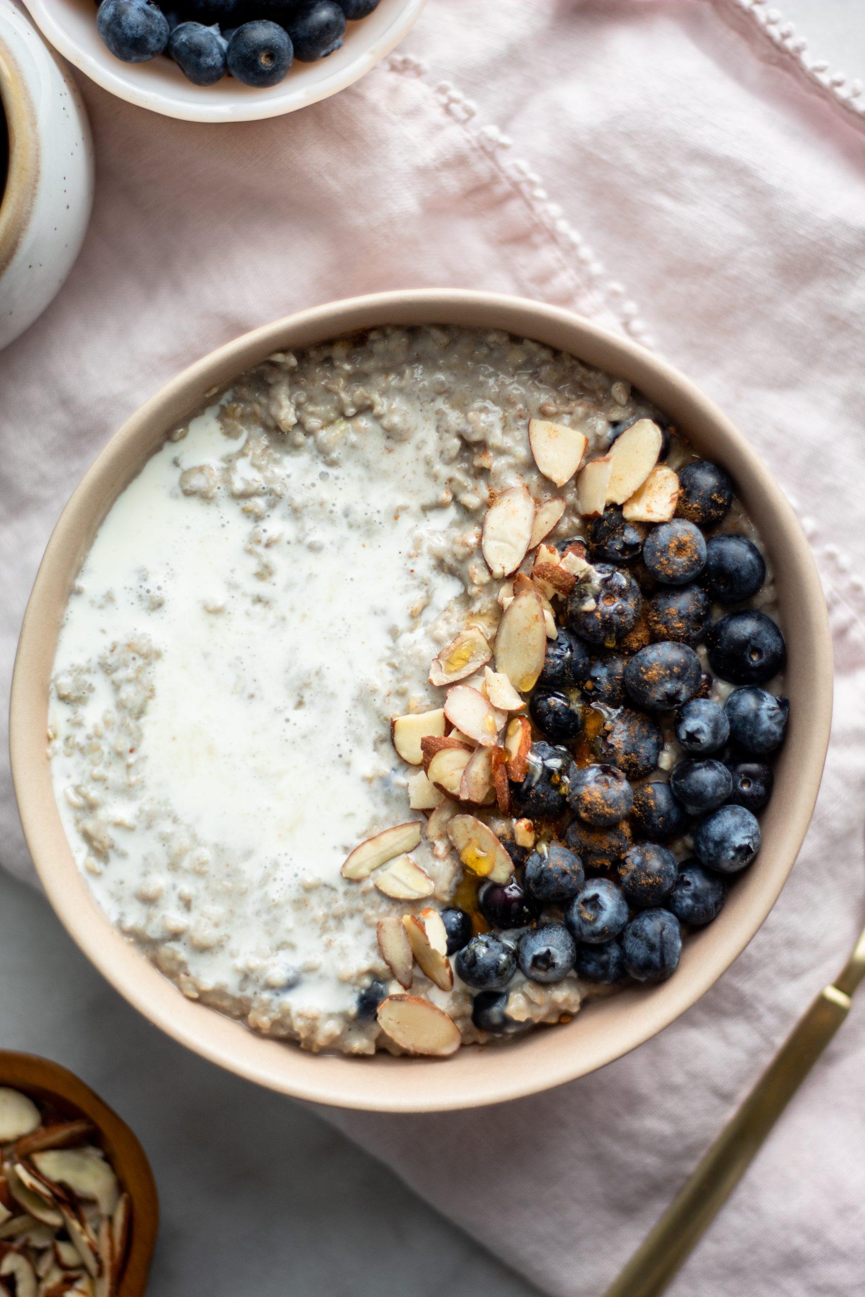 side view of a bowl of blueberry oatmeal showing the creamy texture and layers of blueberries