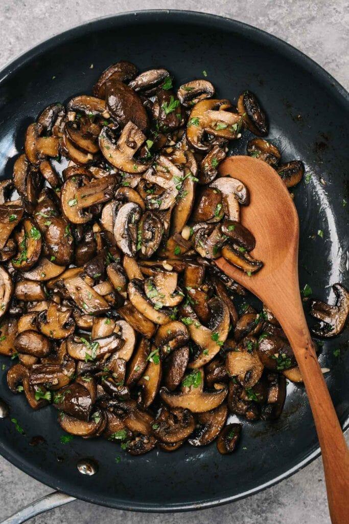 close-up of shiitake mushrooms being sauteed in a pan