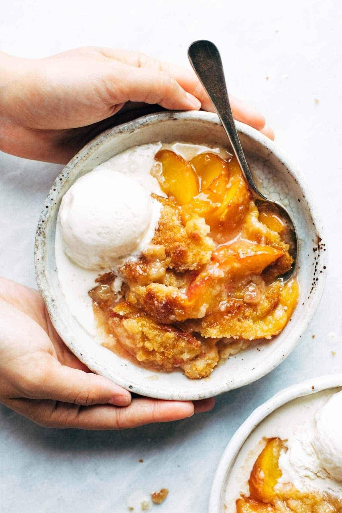 close up of a slice of peach cobbler with ice cream