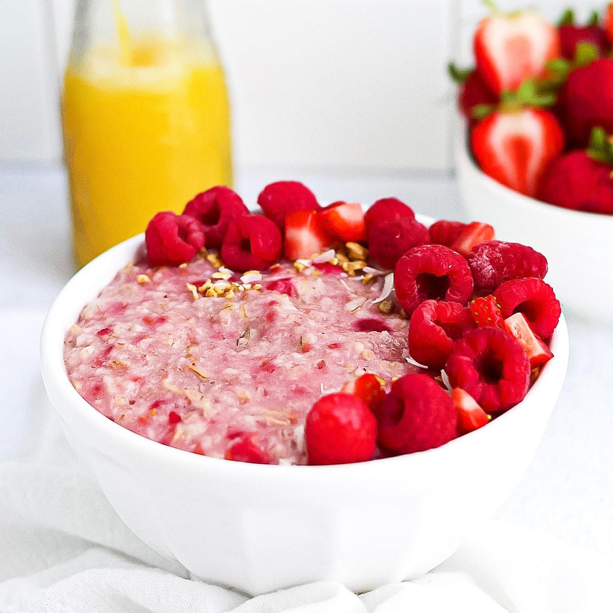 bowl of raspberry oat porridge with fresh raspberries