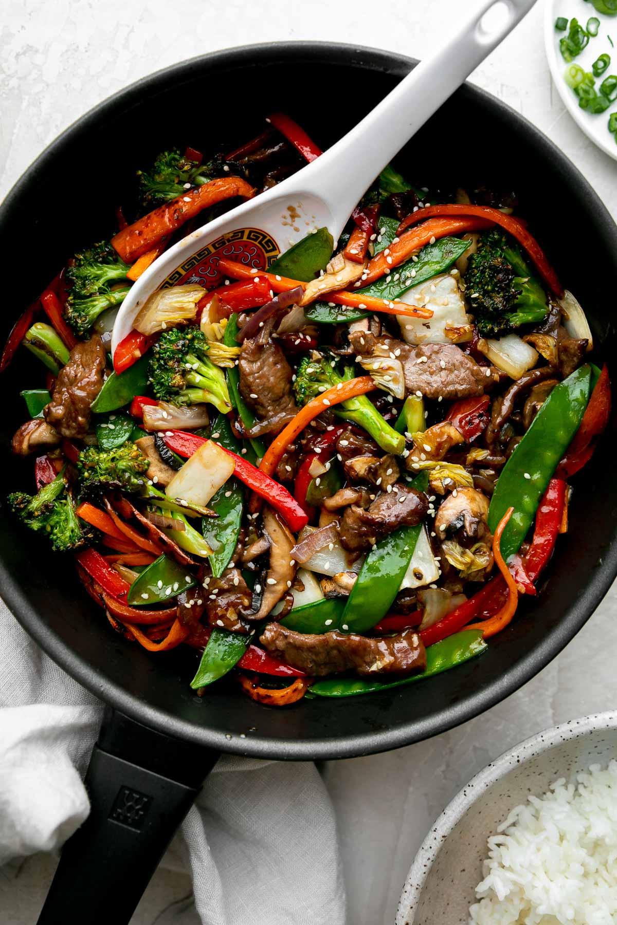close up shot of cooking beef in a wok with vegetables