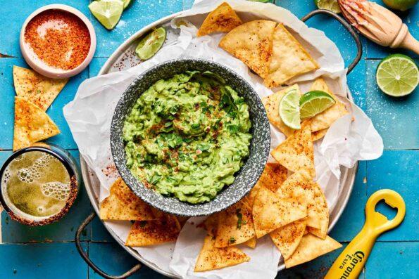 overhead shot of a bowl of guacamole surrounded by tortilla chips