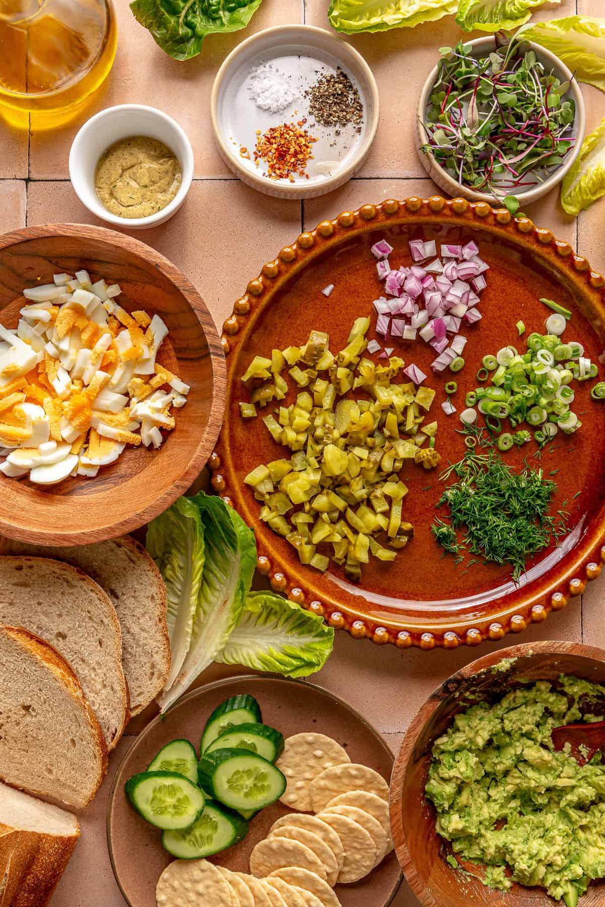 ingredients for avocado and egg salad laid out on a wooden table