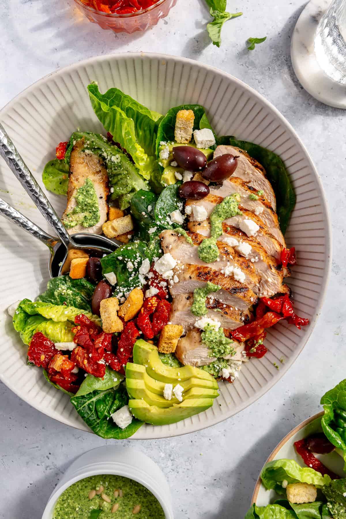 Ingredients for sun-dried tomato pesto chicken salad laid out on a kitchen counter