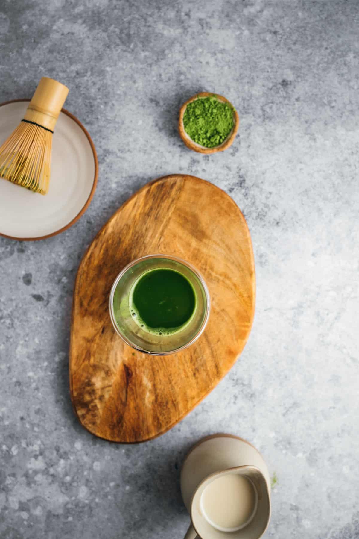 Overhead shot of all the ingredients for Matcha Chai Fusion Latte neatly arranged on a wooden surface