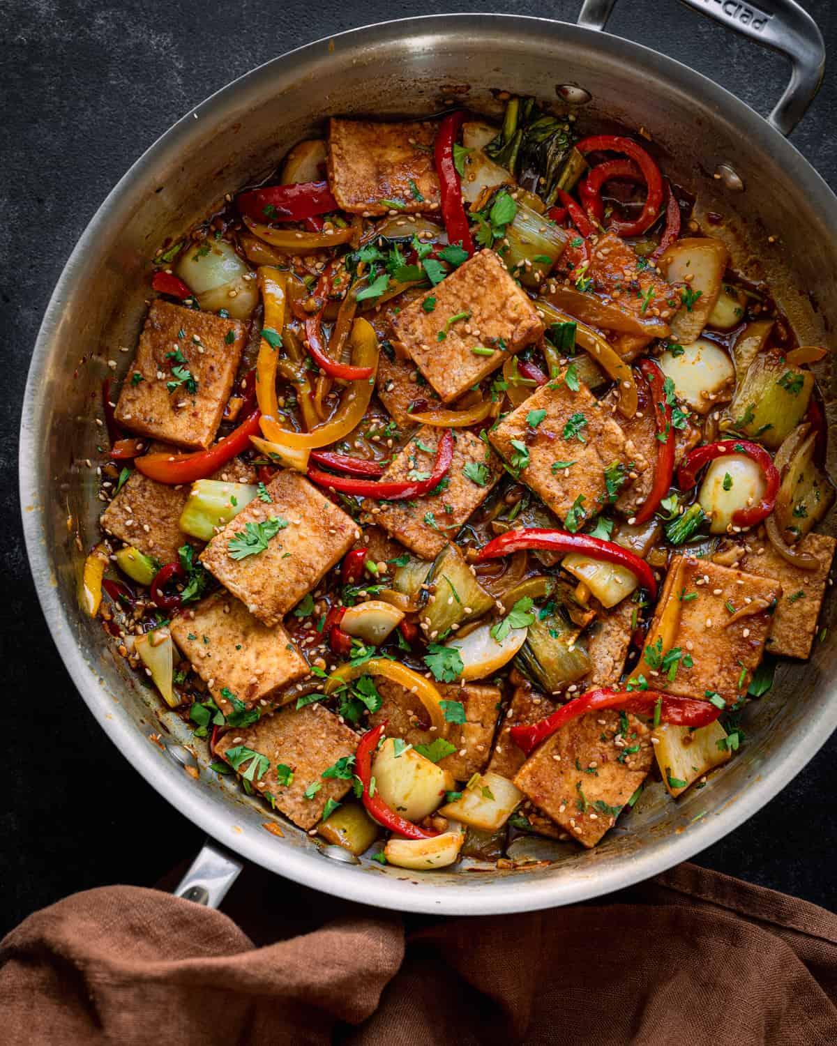 a top-down view of the French herb tofu stir-fry being cooked in a skillet, showing the vibrant colors of the vegetables