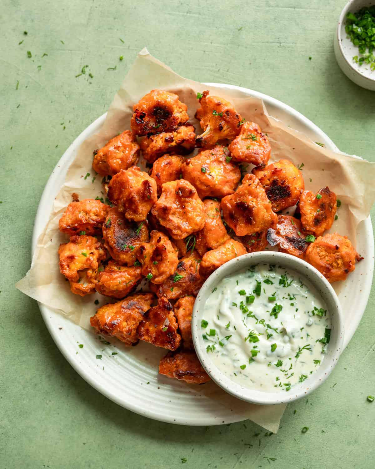 buffalo cauliflower mixture being spooned into bell pepper halves