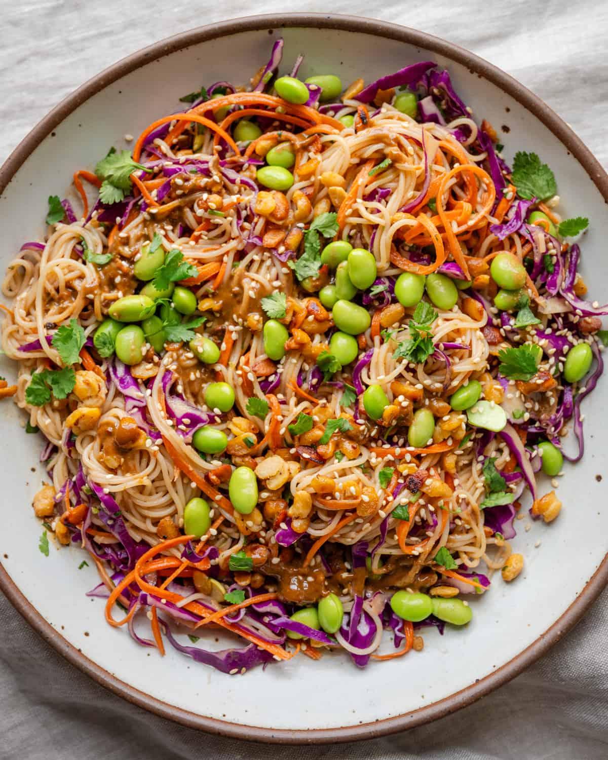 Overhead shot of a colorful Thai noodle salad in a clear container