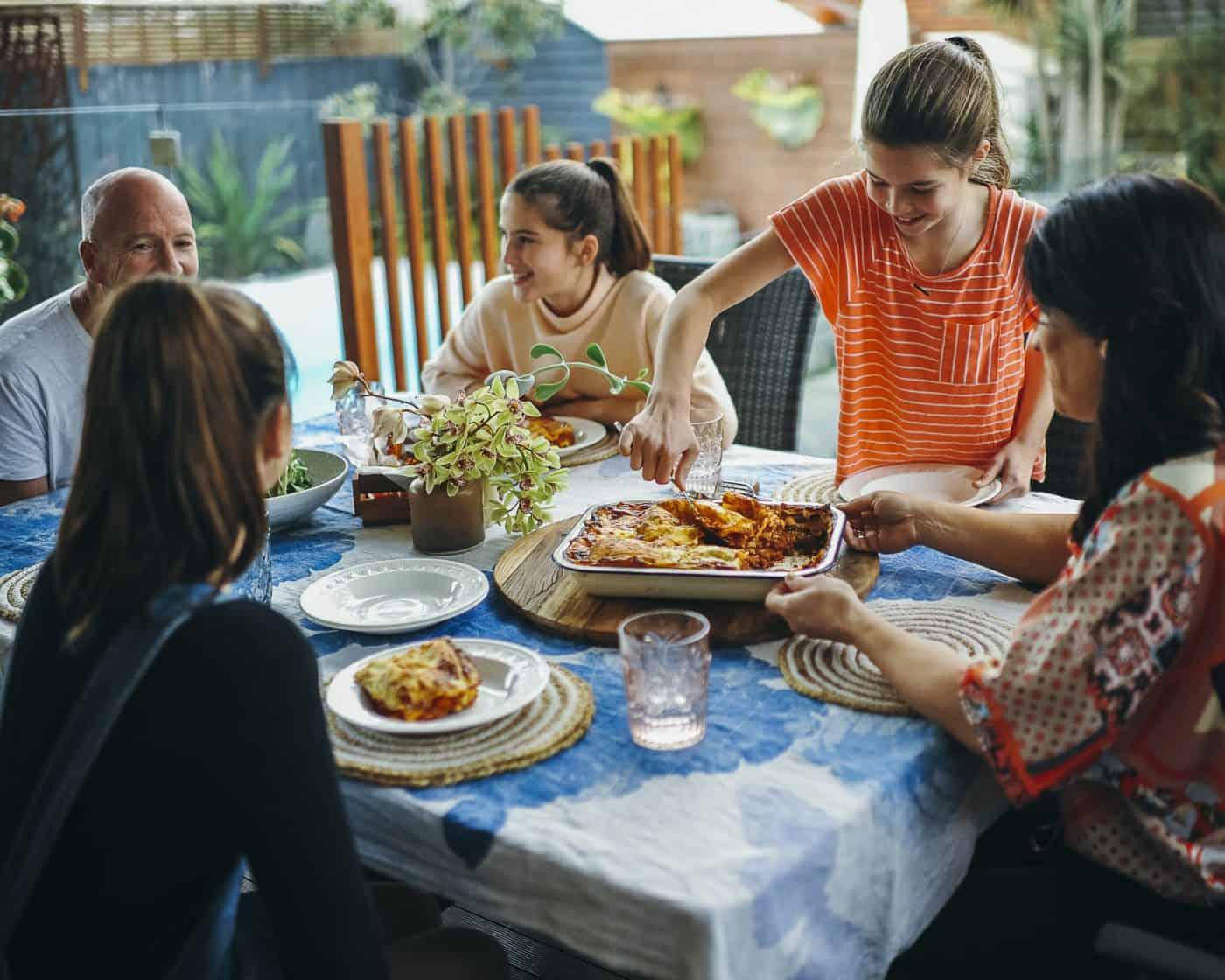 A family enjoying a breakfast lasagna together at a table