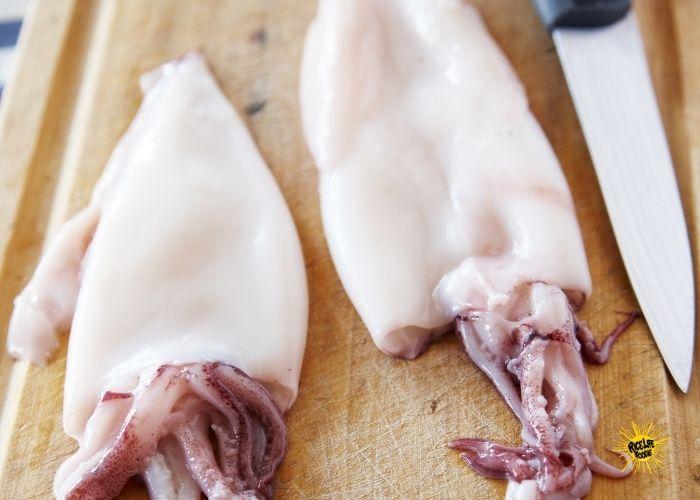 Raw cuttlefish on a cutting board, ready to be prepared for cooking