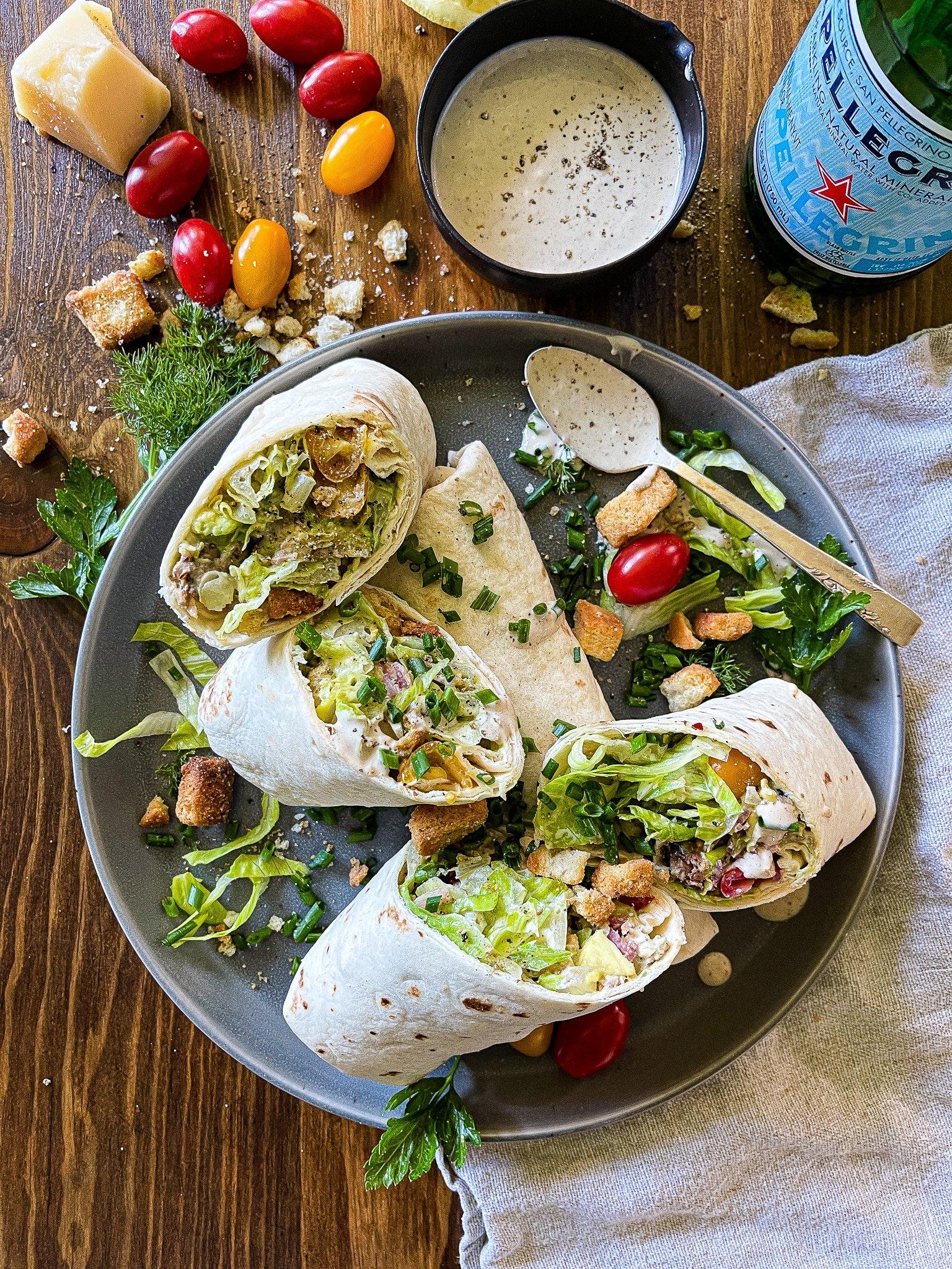 overhead shot of several chicken caesar salad wraps arranged on a plate