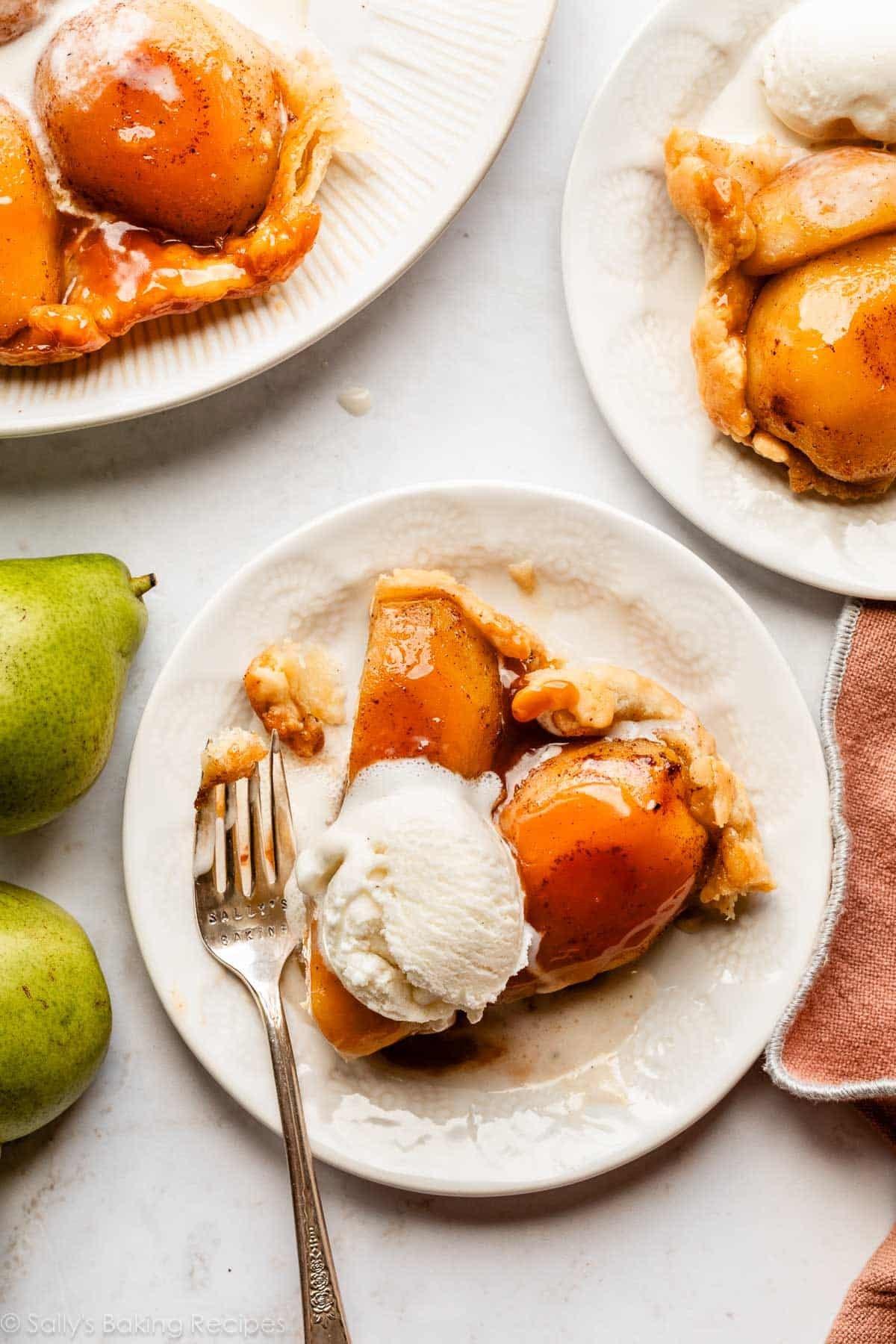 Close-up shot of a slice of pear crisp being scooped out of the baking dish, with a fork lifting it up.