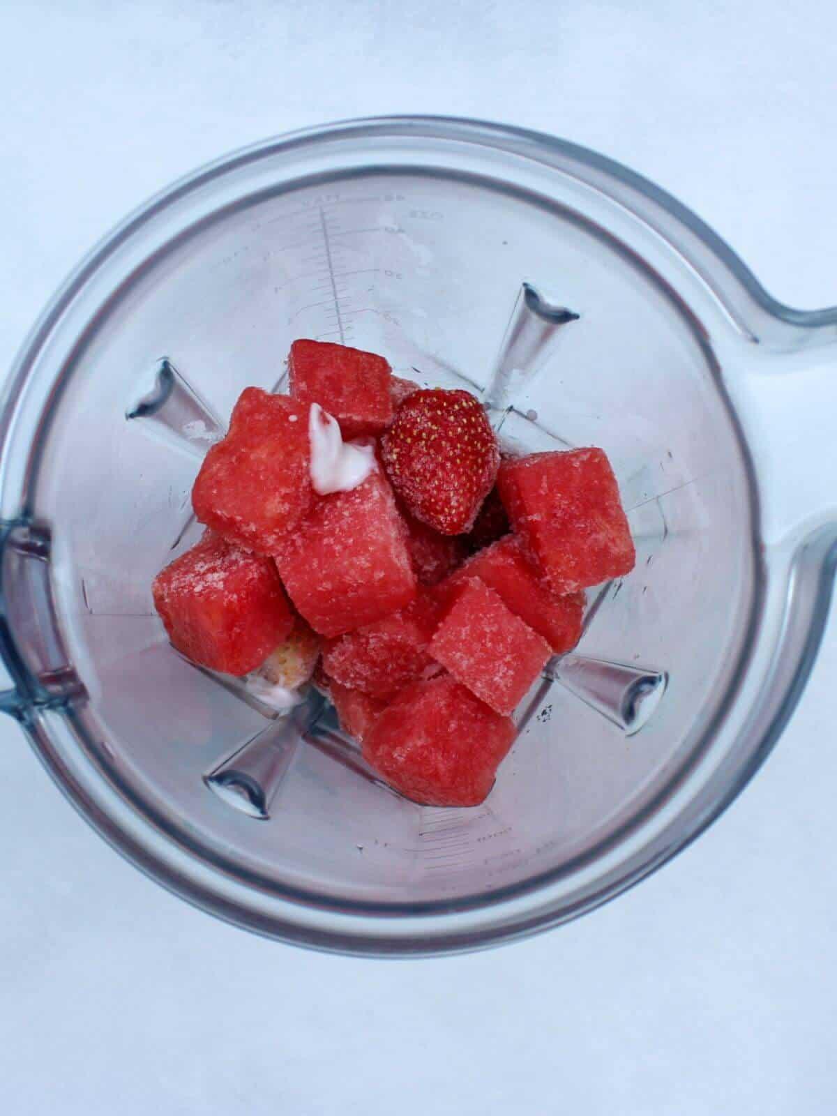 close-up shot of watermelon cubes being mixed with other ingredients in a bowl